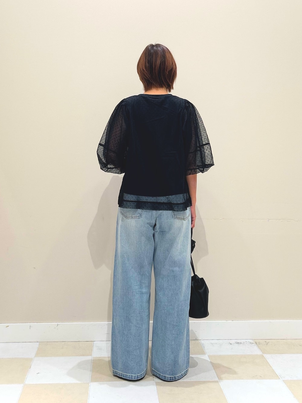 ブラック系のTシャツ/カットソー、ブルー系のデニムパンツ、ブラック系のショルダーバッグを着用したレディースの夏コーディネートの3枚目の写真