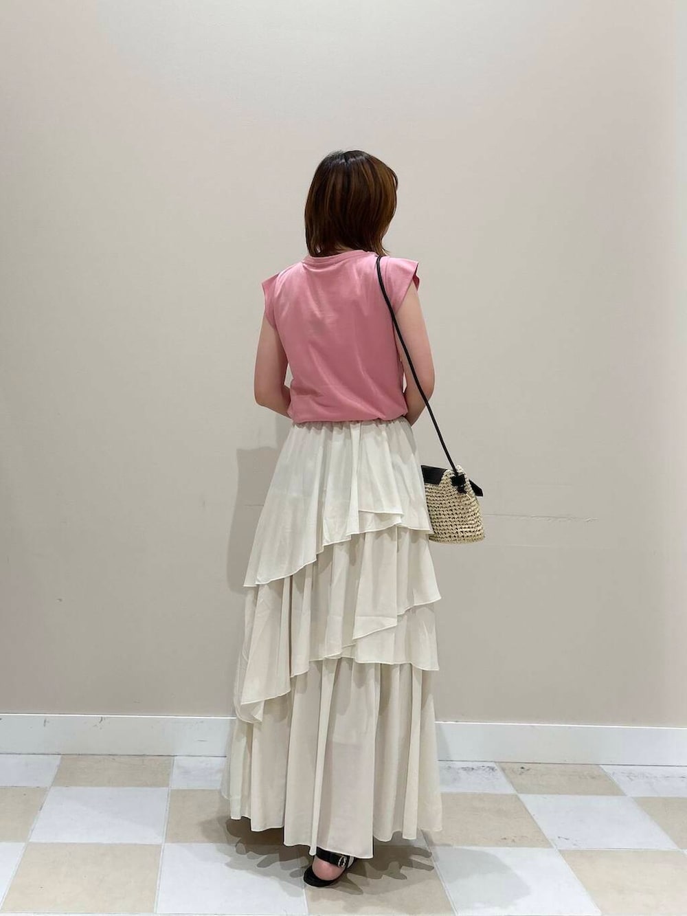 ベージュ系のショルダーバッグ、ホワイト系のスカート、ピンク系のTシャツ/カットソーを着用したレディースの夏コーディネートの2枚目の写真