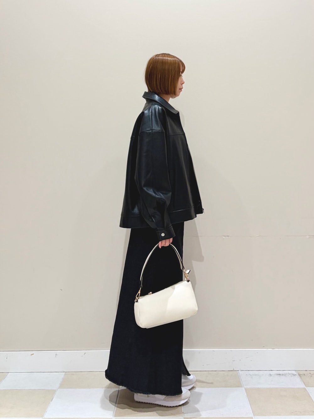 パープル系のニット/セーター、ブラック系のブルゾン、ブラック系のスカートを着用したレディースの冬コーディネートの2枚目の写真