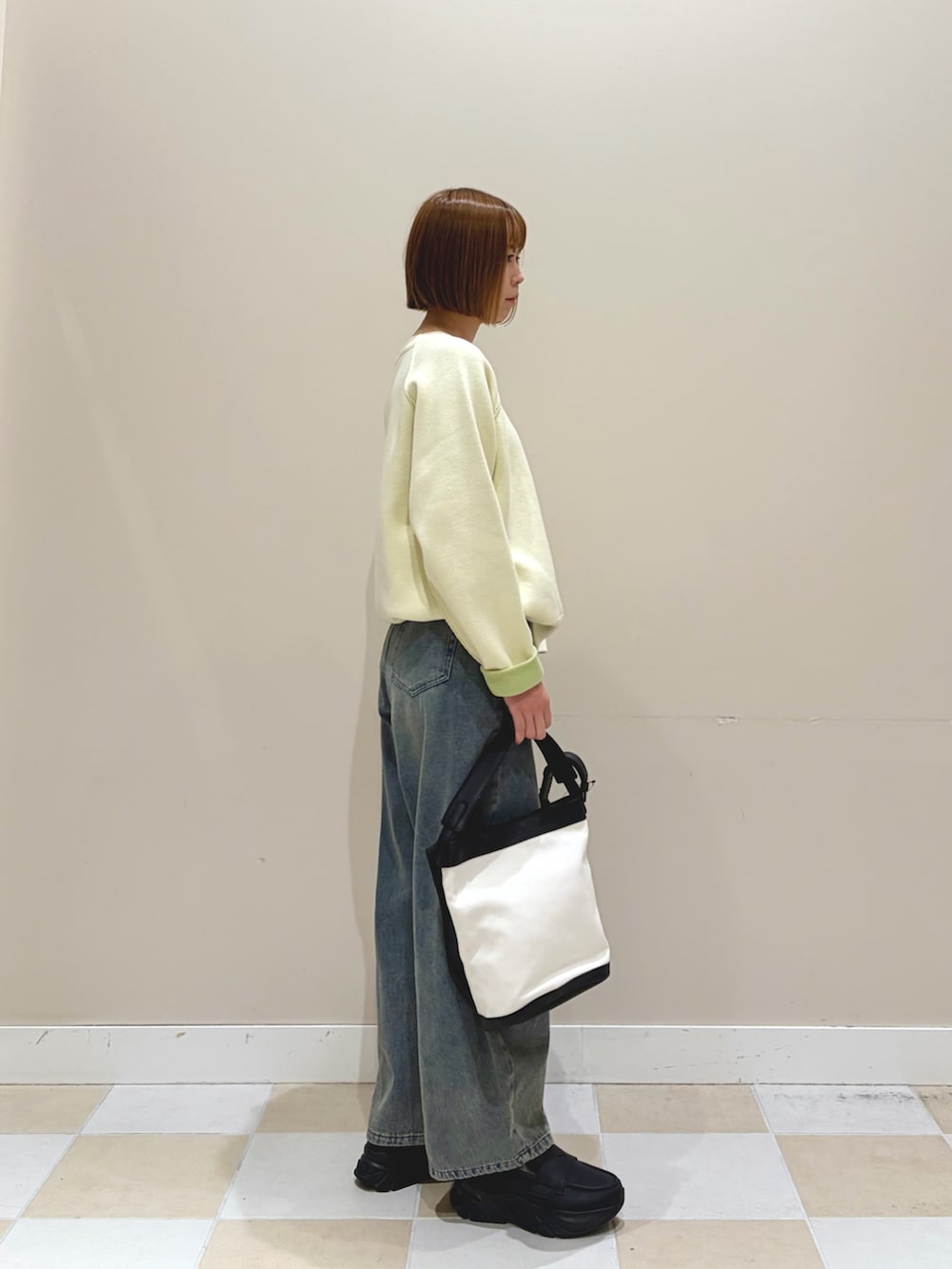 ホワイト系のニット/セーター、ブルー系のデニムパンツを着用したレディースの冬コーディネートの2枚目の写真