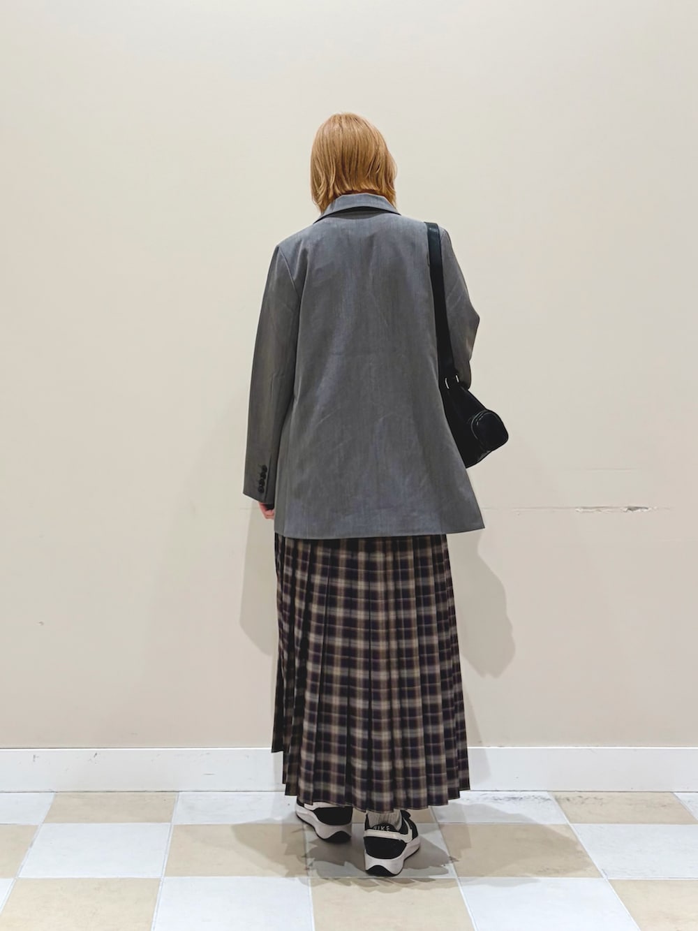 ブルー系のスカート、グレー系のテーラードジャケットを着用したレディースの春コーディネートの3枚目の写真