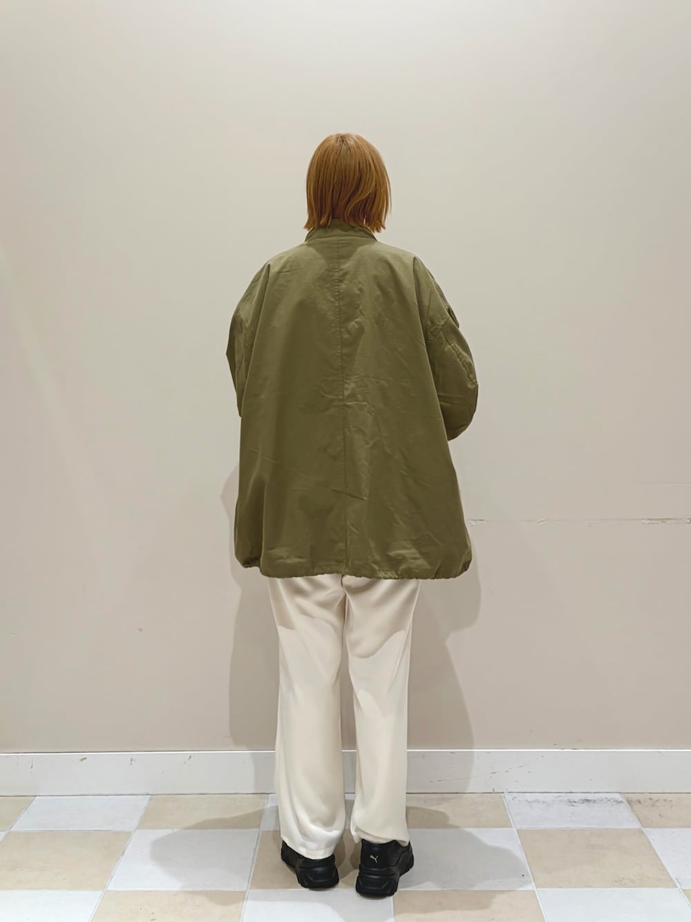 ホワイト系のその他パンツ、グリーン系のモッズコート、ベージュ系のニット/セーターを着用したレディースの春コーディネートの3枚目の写真