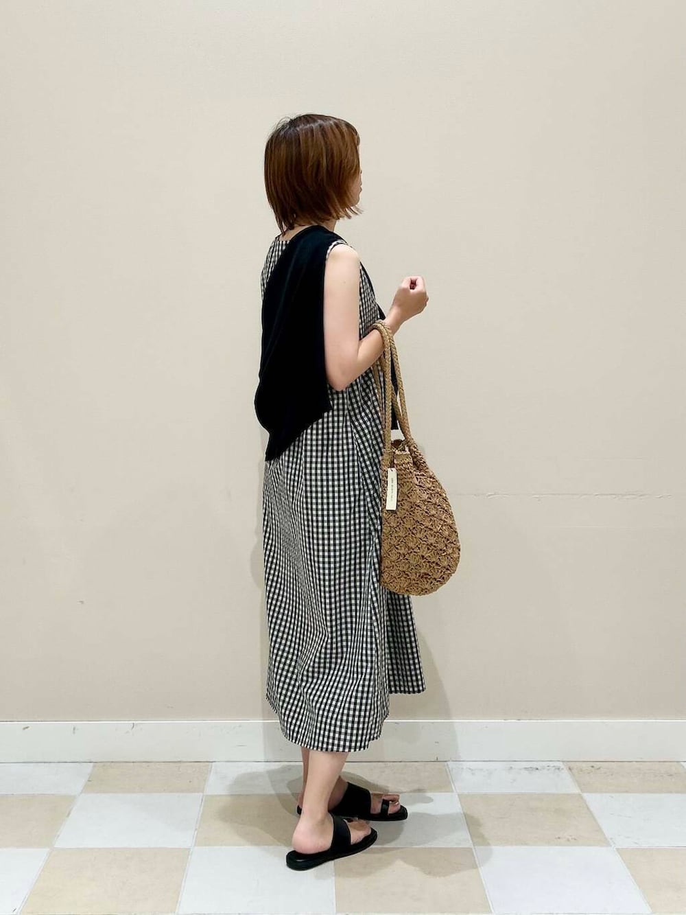 ベージュ系のトートバッグ、ブラック系のカーディガン/ボレロ、その他のワンピースを着用したレディースの夏コーディネートの2枚目の写真