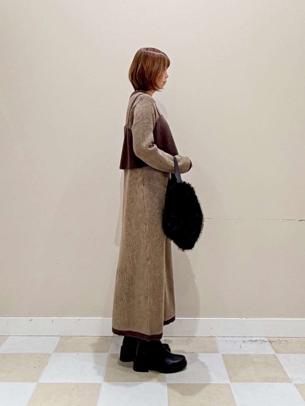 ブラウン系のワンピース、ブラック系のブーツを着用したレディースの秋コーディネートの2枚目の写真