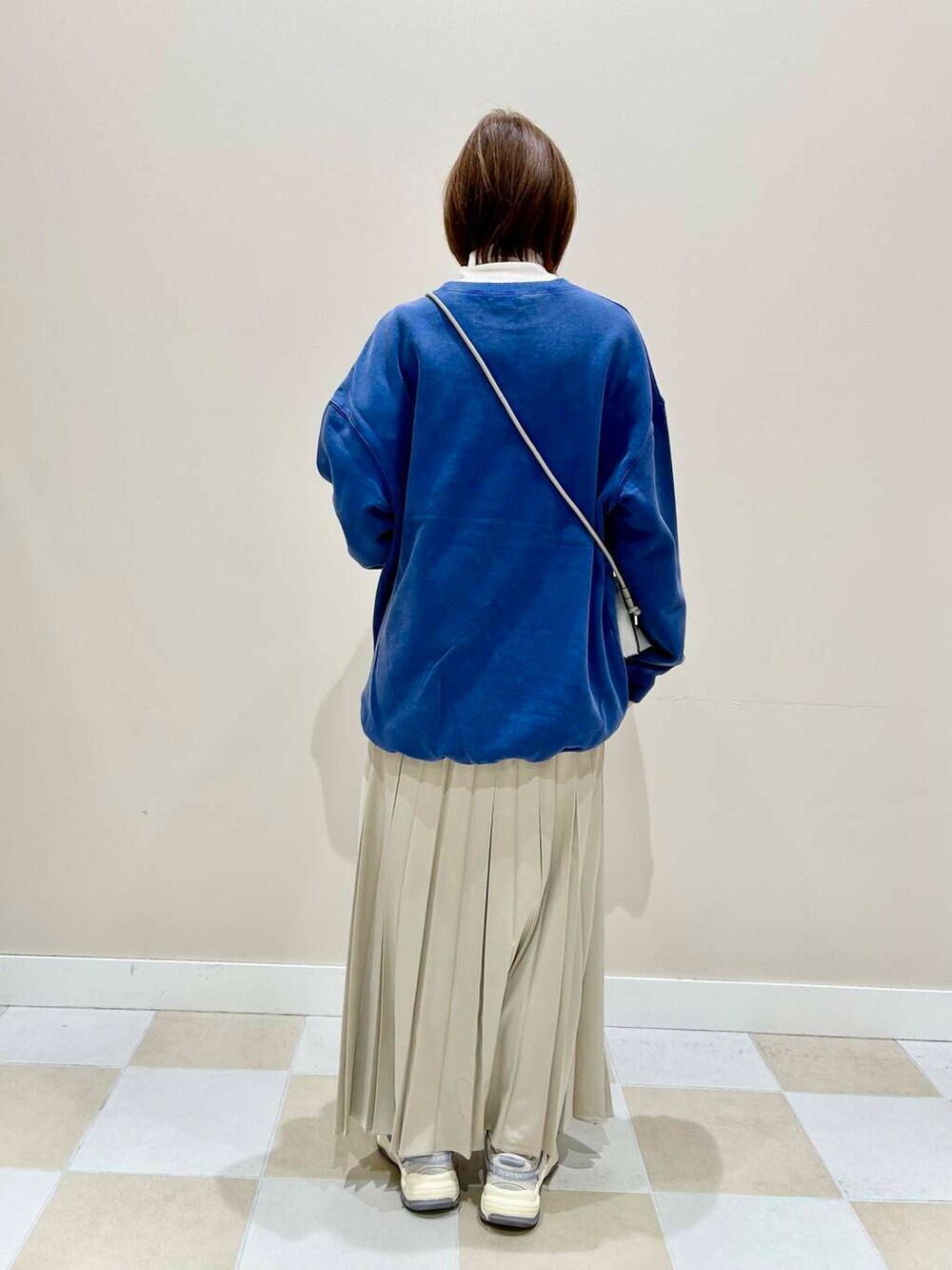 シルバー系のショルダーバッグ、ブルー系のTシャツ/カットソーを着用したレディースの冬コーディネートの3枚目の写真