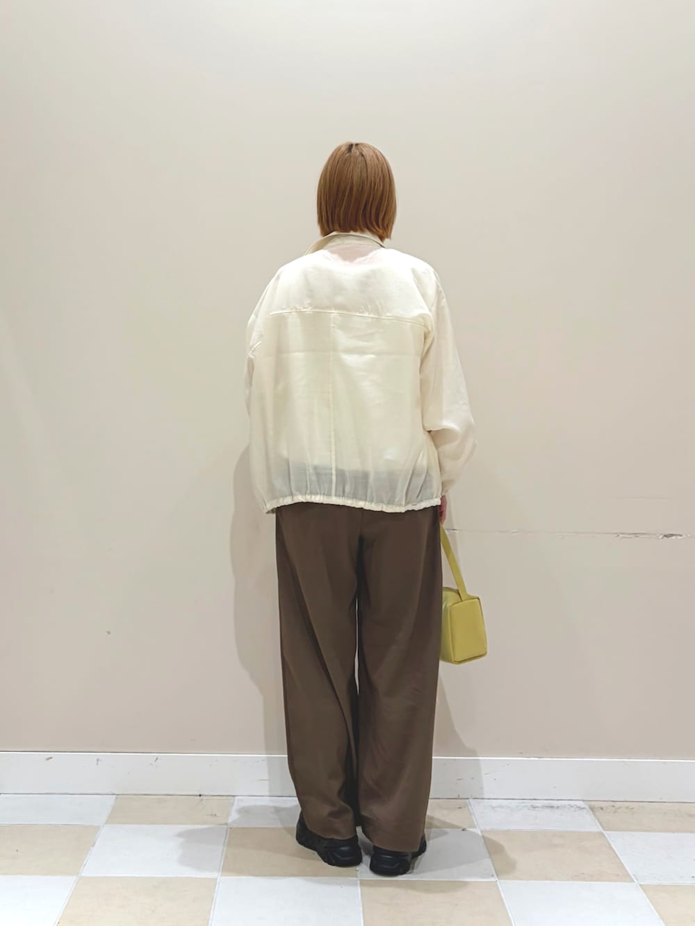 ホワイト系のブルゾン、グリーン系のその他パンツ、イエロー系のトートバッグを着用したレディースの春コーディネートの3枚目の写真