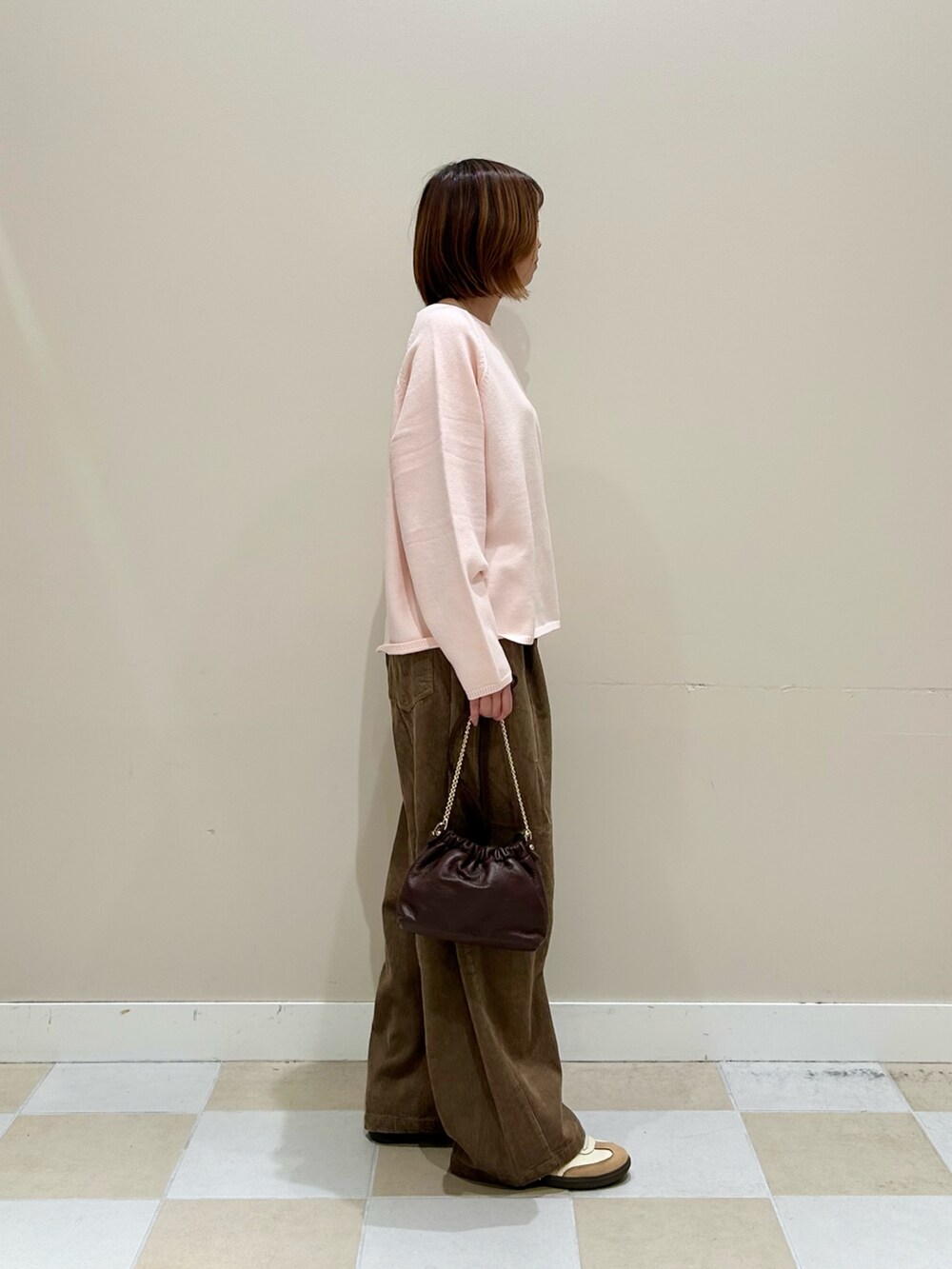 ピンク系のニット/セーター、ベージュ系のその他パンツ、ブラウン系のショルダーバッグを着用したレディースの秋コーディネートの2枚目の写真