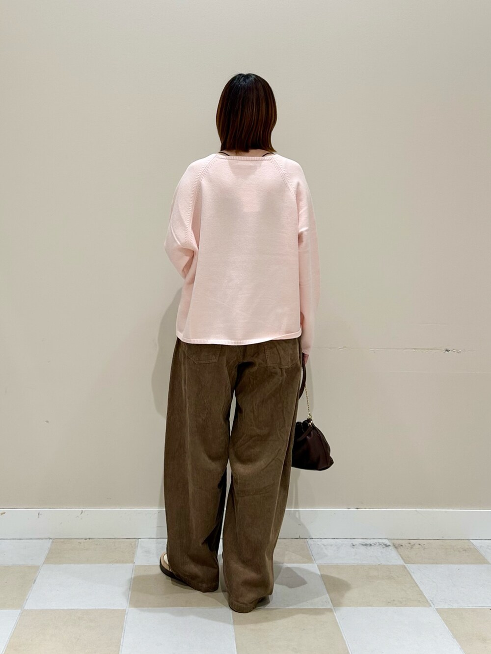 ピンク系のニット/セーター、ベージュ系のその他パンツ、ブラウン系のショルダーバッグを着用したレディースの秋コーディネートの3枚目の写真
