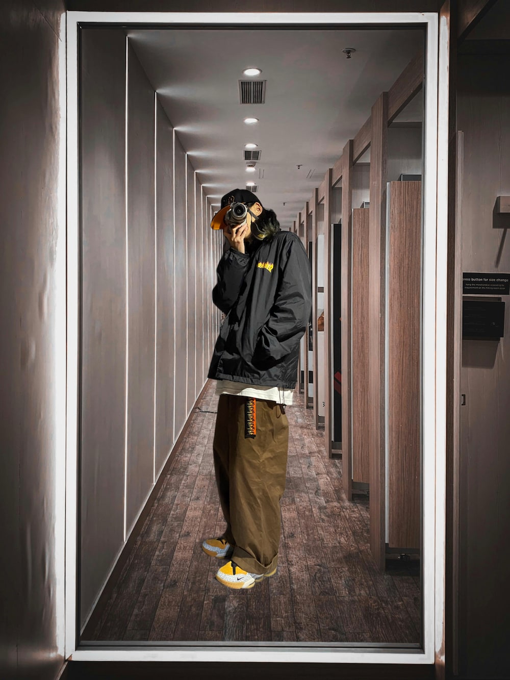 ホワイト系のTシャツ/カットソー、ブラック系のナイロンジャケット、ブラウン系のパンツを着用したメンズの冬コーディネートの2枚目の写真