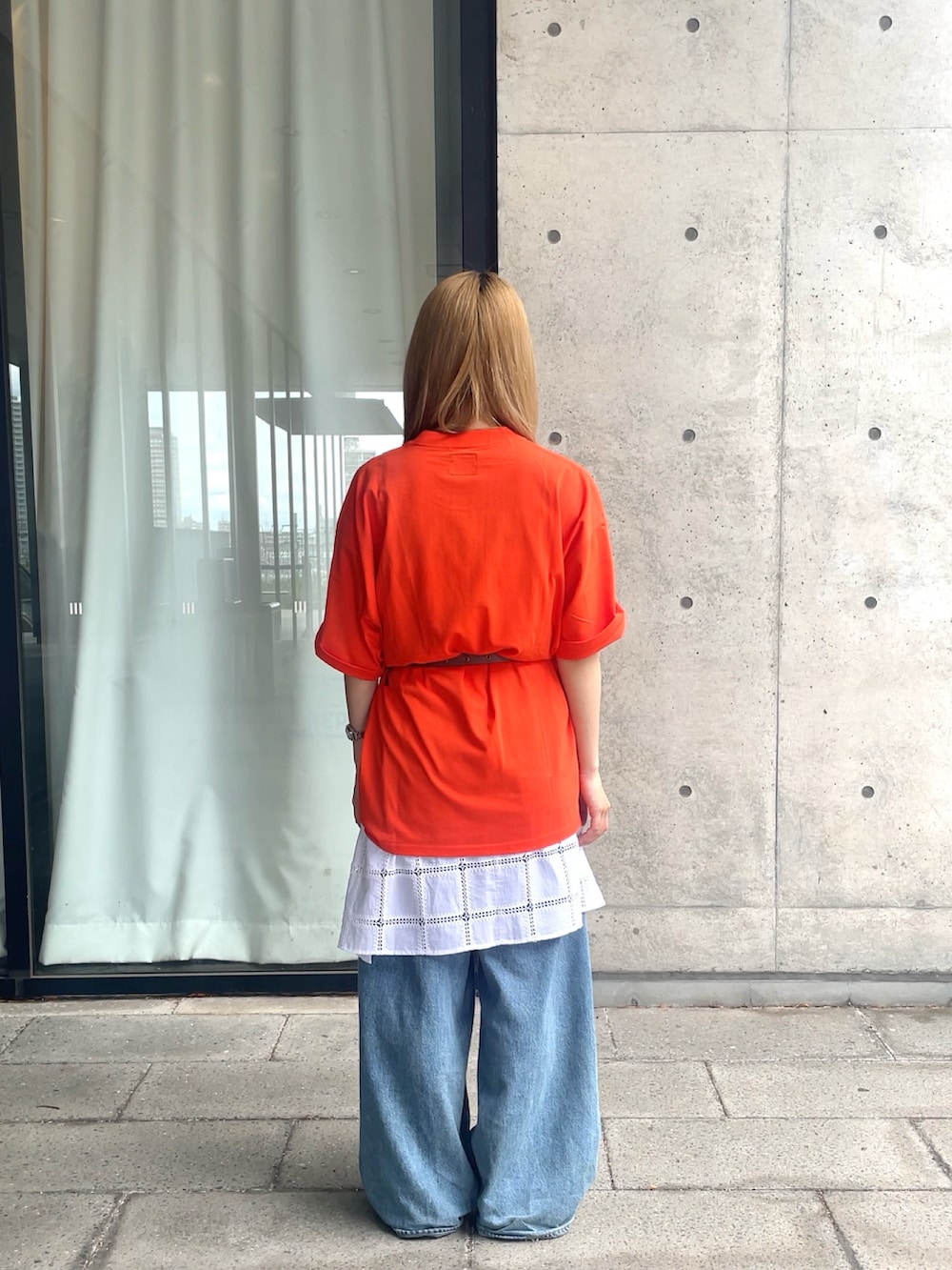オレンジ系のTシャツ/カットソー、ホワイト系のワンピースを着用したレディースの春コーディネートの2枚目の写真