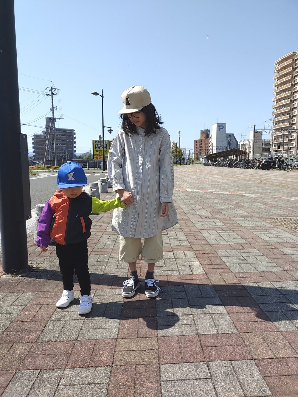 ブラック系のスニーカー、ホワイト系のその他パンツ、ブルー系のワンピースを着用したキッズの春コーディネートの3枚目の写真