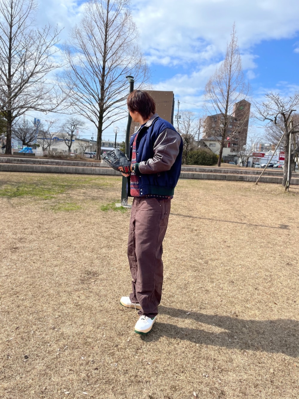 ブルー系のスタジャン、ブルー系のニット/セーター、ブラウン系のその他パンツを着用したメンズの冬コーディネートの2枚目の写真