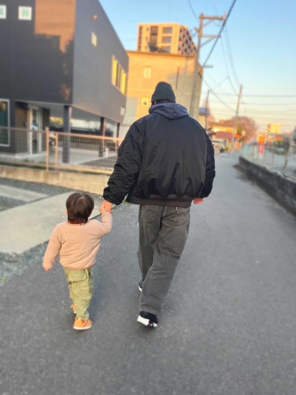 ブルー系のパーカー、ブラック系のMA-1、グリーン系のベストを着用したメンズの冬コーディネートの3枚目の写真