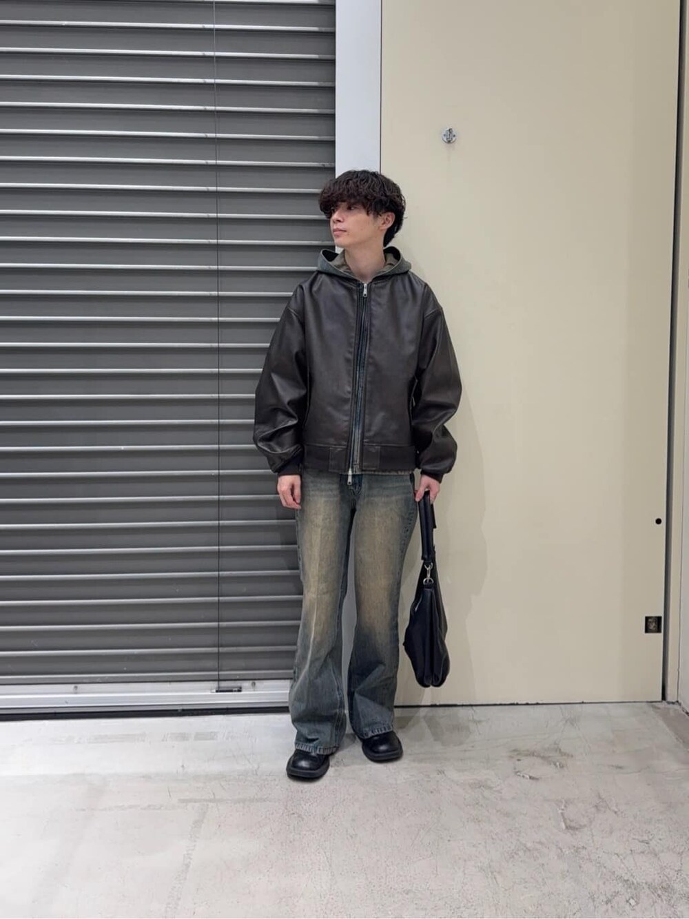 ブラウン系のブルゾン、ブルー系のパーカー、ブルー系のデニムパンツを着用したメンズの秋コーディネートの2枚目の写真