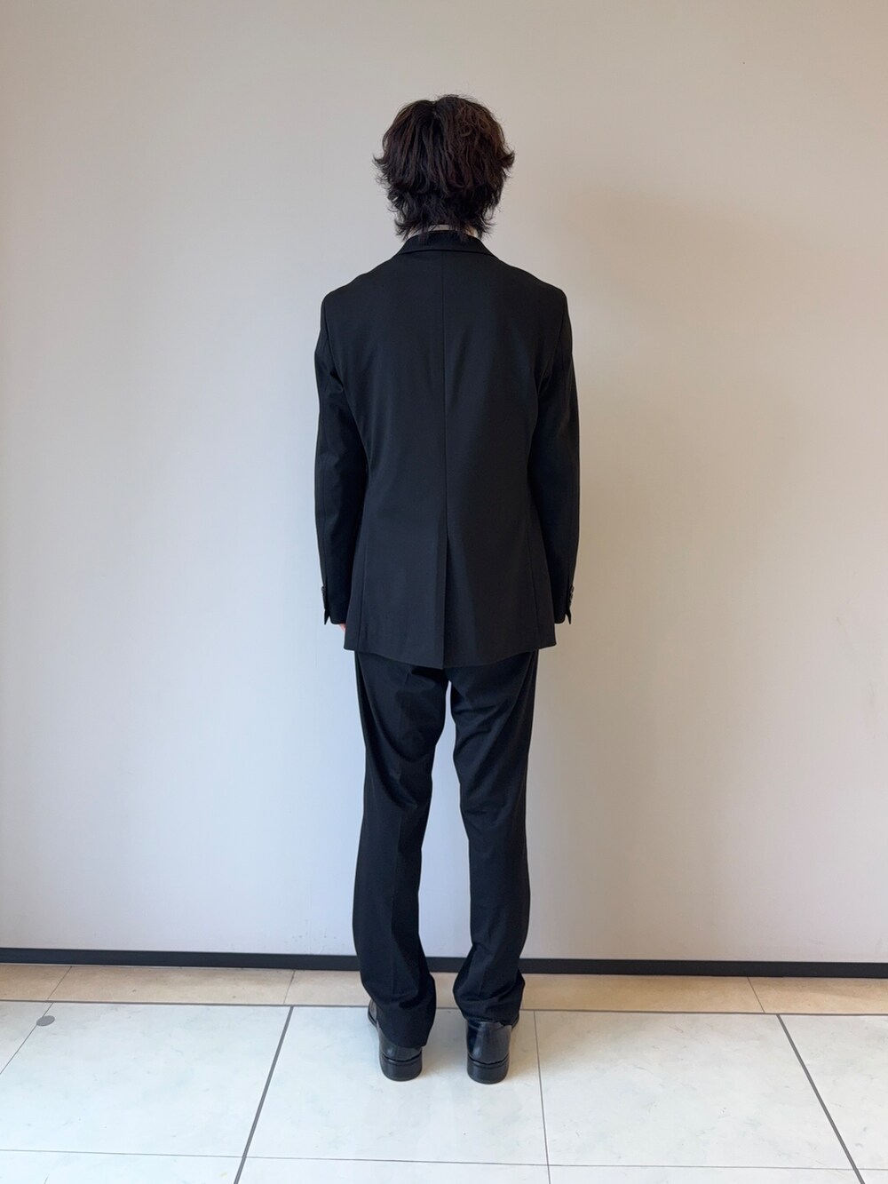 ブラック系のスラックス、ブラック系のテーラードジャケット、ホワイト系のシャツ/ブラウスを着用したメンズの秋コーディネートの4枚目の写真