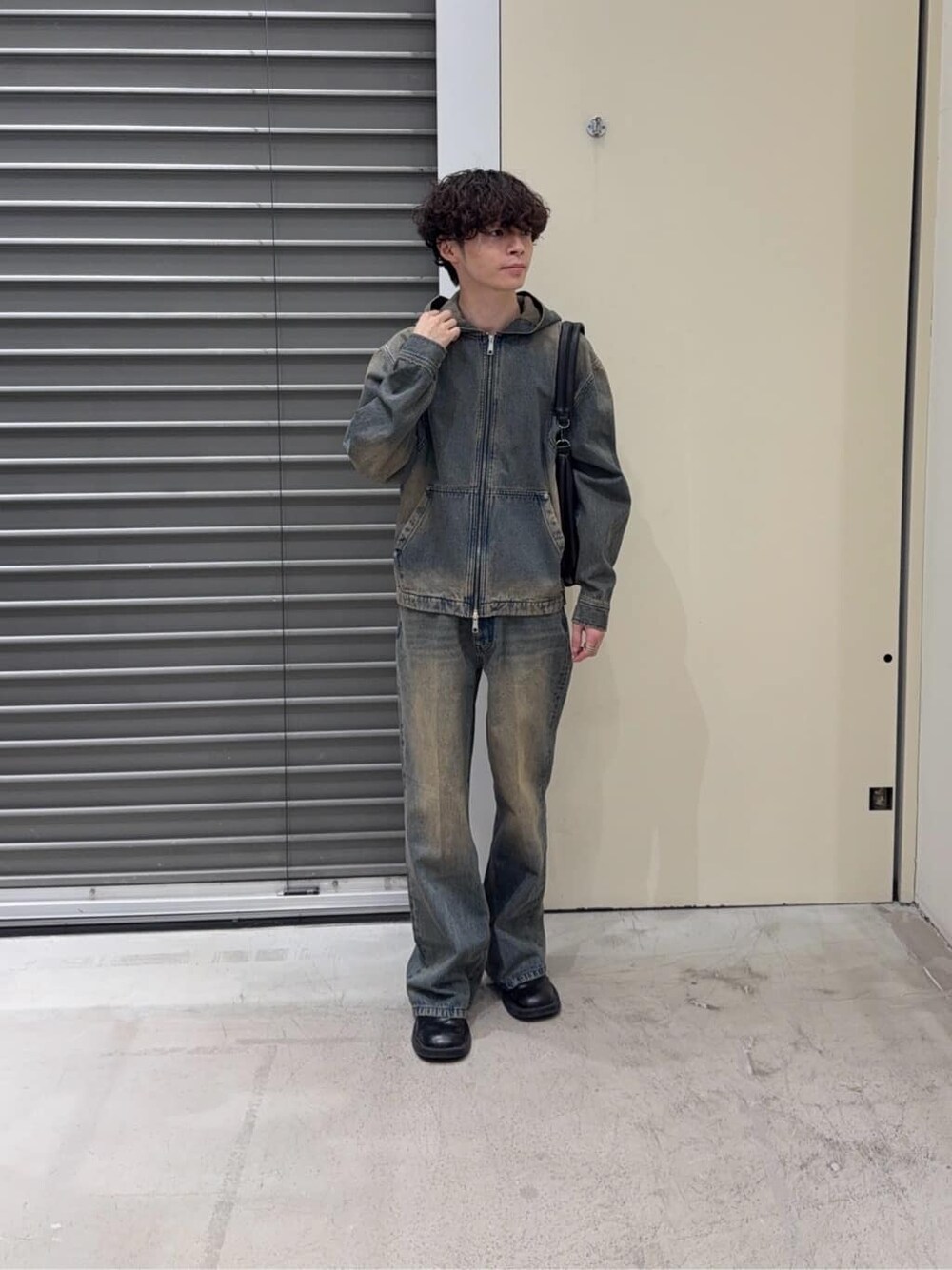 ブラウン系のブルゾン、ブルー系のパーカー、ブルー系のデニムパンツを着用したメンズの秋コーディネートの3枚目の写真