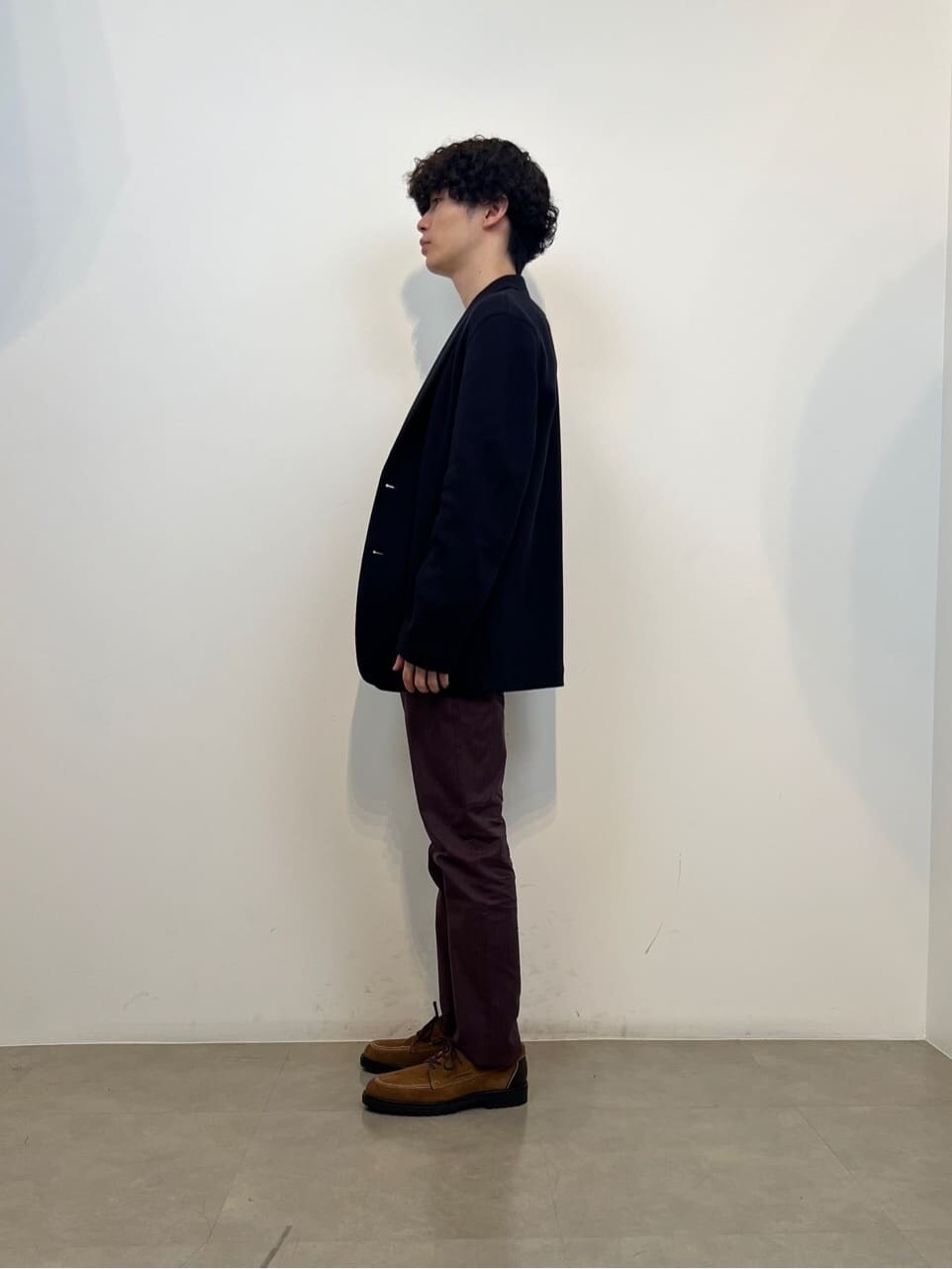レッド系のスラックスを着用したメンズの秋コーディネートの2枚目の写真