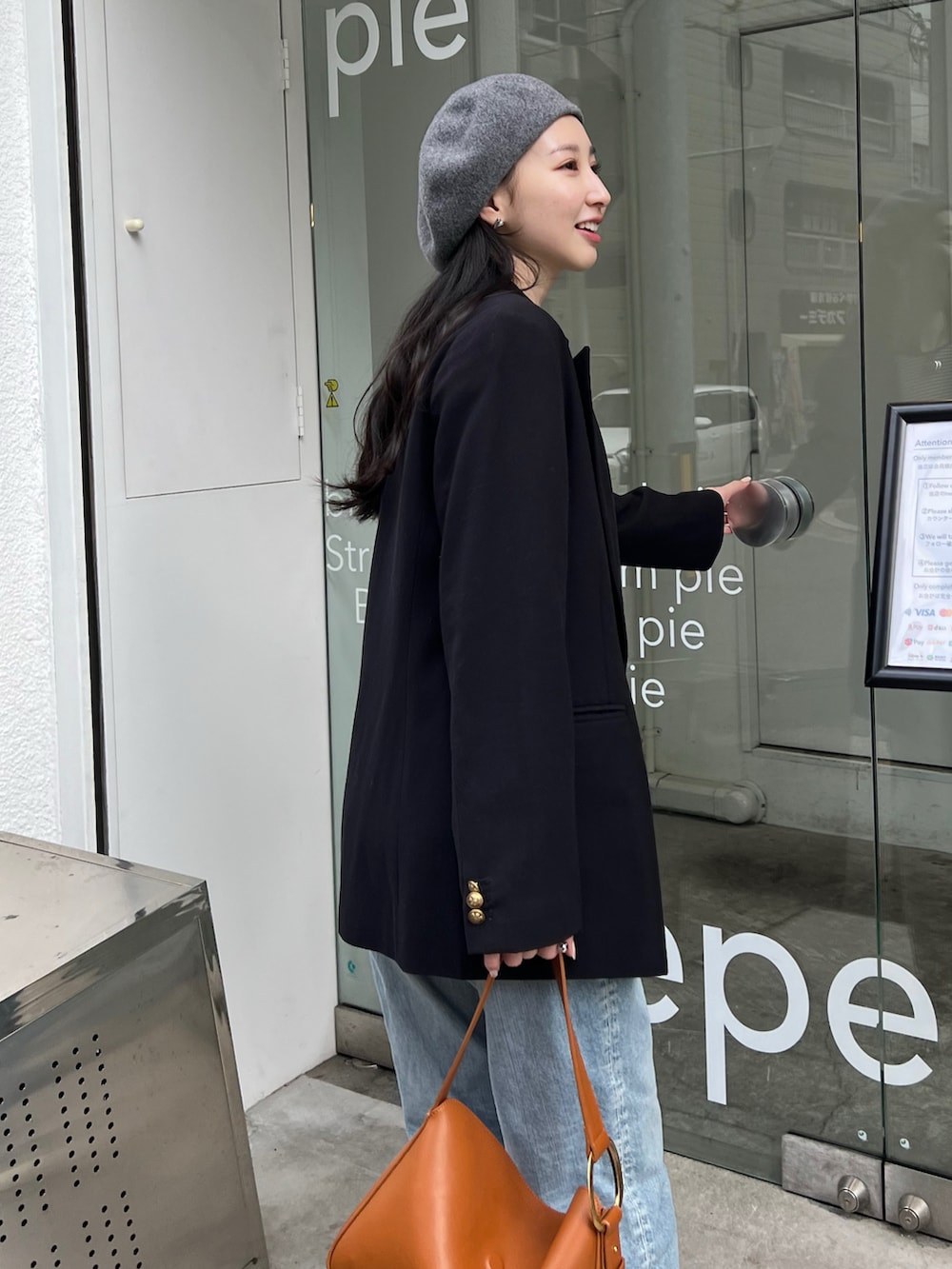 ブルー系のテーラードジャケット、ブルー系のデニムパンツ、ホワイト系のパンプスを着用したレディースの冬コーディネートの2枚目の写真