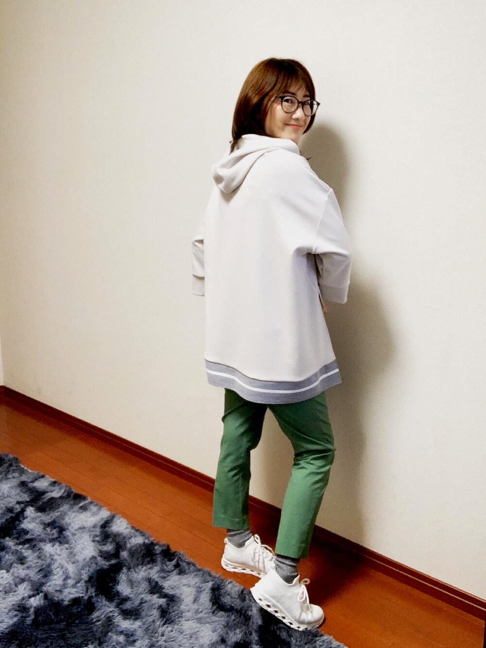 ホワイト系のパーカー、グリーン系のパンツを着用したレディースの春コーディネートの2枚目の写真