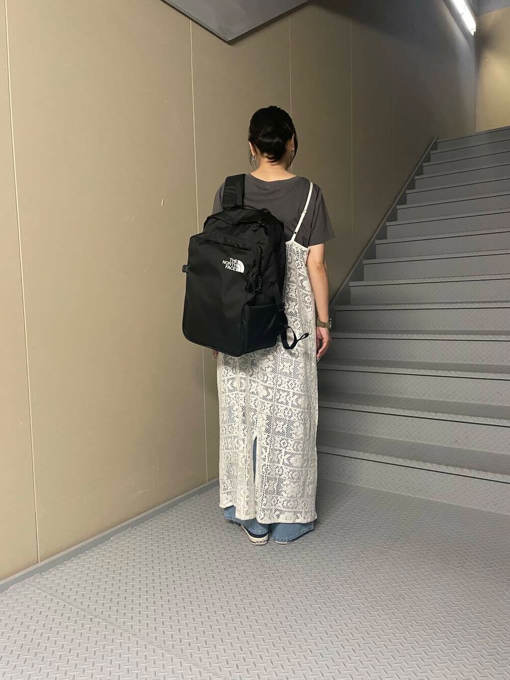 ブラック系のバックパック/リュック、ブルー系のデニムパンツ、ブラック系のTシャツ/カットソーを着用したレディースの夏コーディネートの2枚目の写真