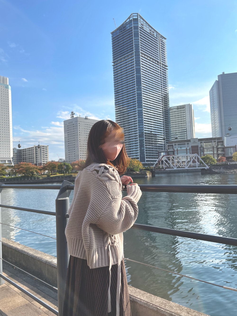 ブルー系のトートバッグ、ブラック系のブーツ、ブラウン系のカーディガン/ボレロを着用したレディースの冬コーディネートの2枚目の写真