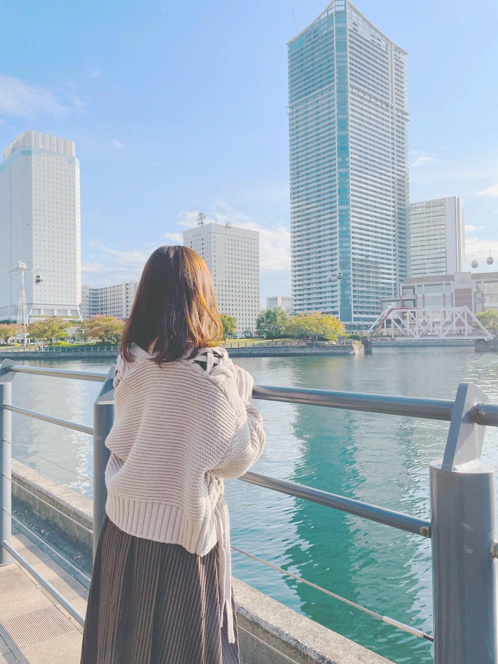 ブルー系のトートバッグ、ブラック系のブーツ、ブラウン系のカーディガン/ボレロを着用したレディースの冬コーディネートの3枚目の写真