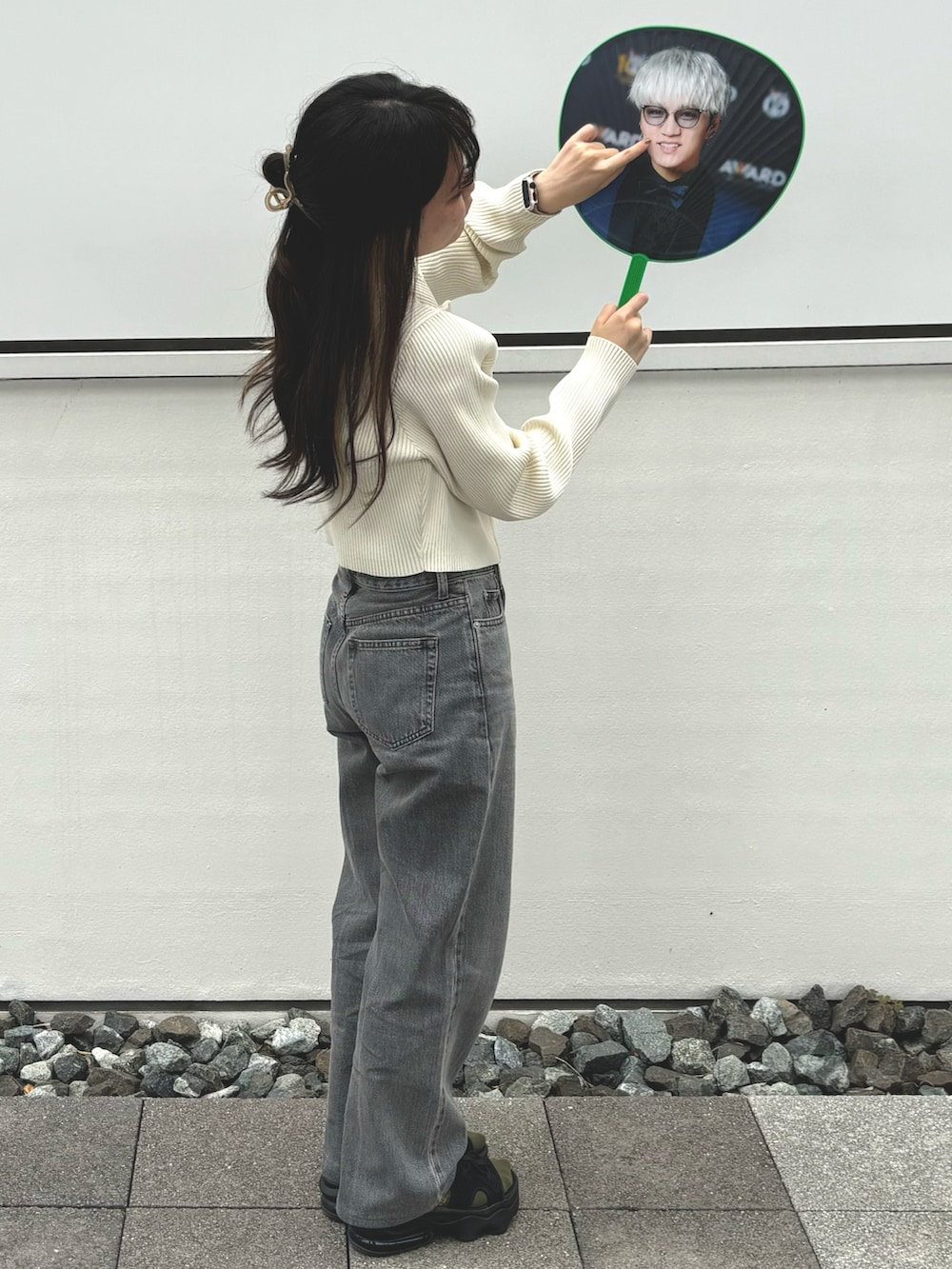 ホワイト系のニット/セーター、ブラック系のサンダル、ベージュ系のスマホグッズを着用したレディースの夏コーディネートの2枚目の写真