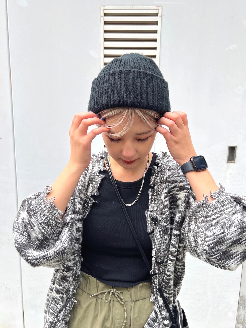 ブラック系のカーディガン/ボレロ、ブラック系のショルダーバッグ、グリーン系のカーゴパンツを着用したレディースの冬コーディネートの4枚目の写真