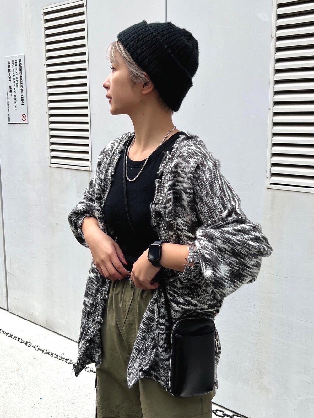 ブラック系のカーディガン/ボレロ、ブラック系のショルダーバッグ、グリーン系のカーゴパンツを着用したレディースの冬コーディネートの5枚目の写真