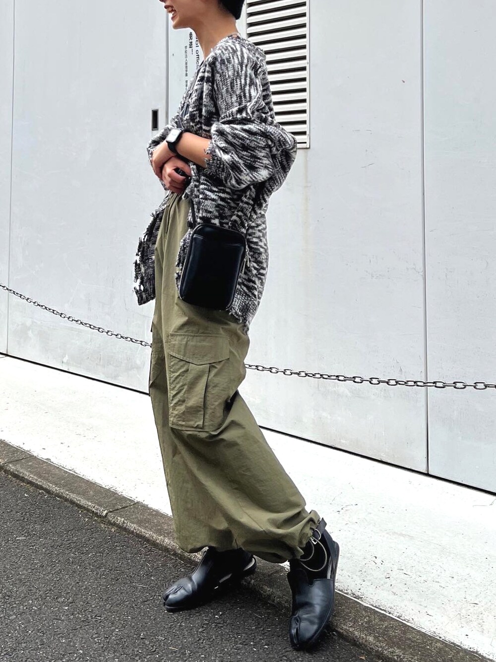 ブラック系のカーディガン/ボレロ、ブラック系のショルダーバッグ、グリーン系のカーゴパンツを着用したレディースの冬コーディネートの3枚目の写真