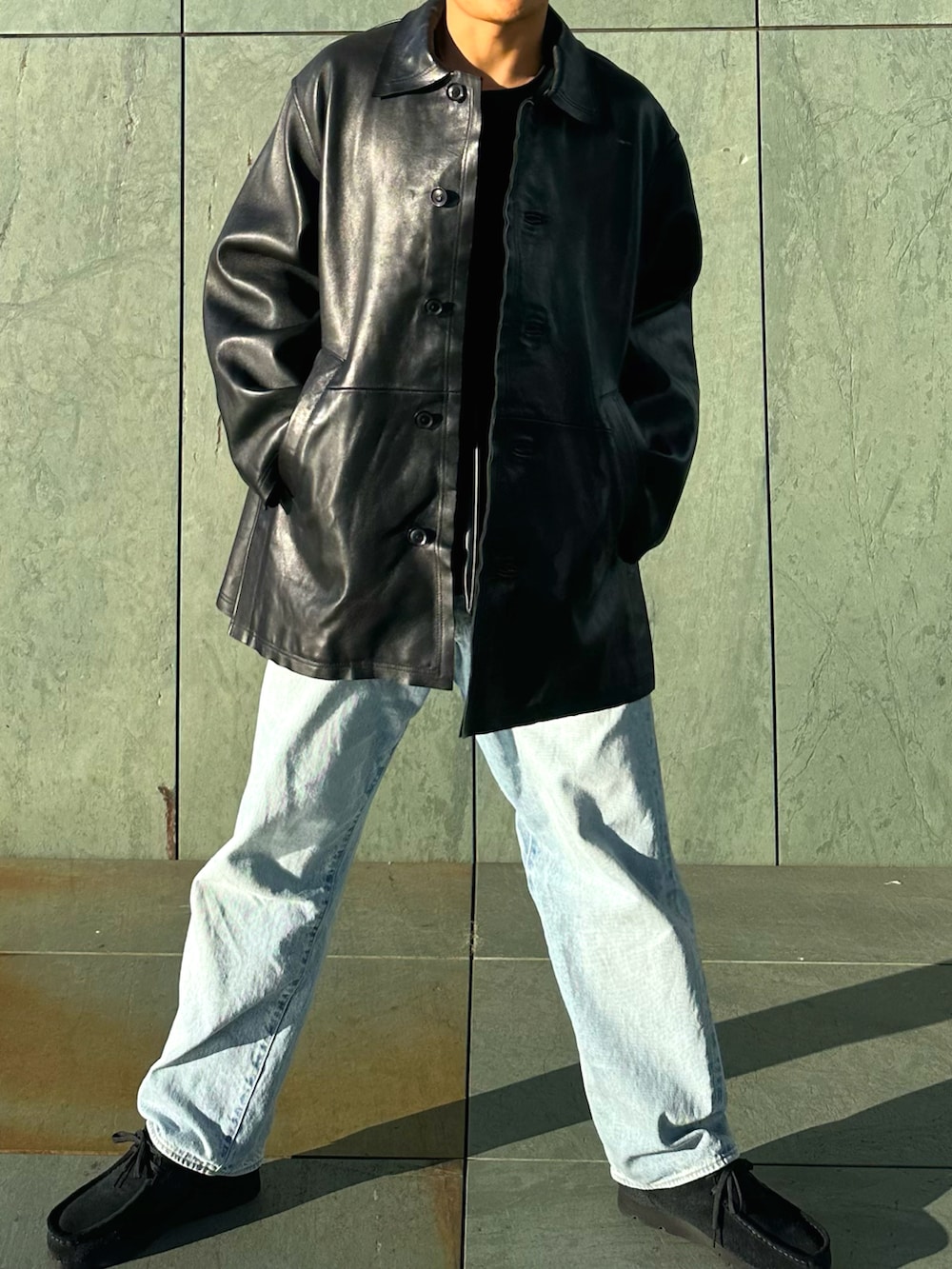 ブラック系のその他アウター、ブルー系のデニムパンツ、ブラック系のモカシン/デッキシューズを着用したメンズの秋コーディネートの3枚目の写真