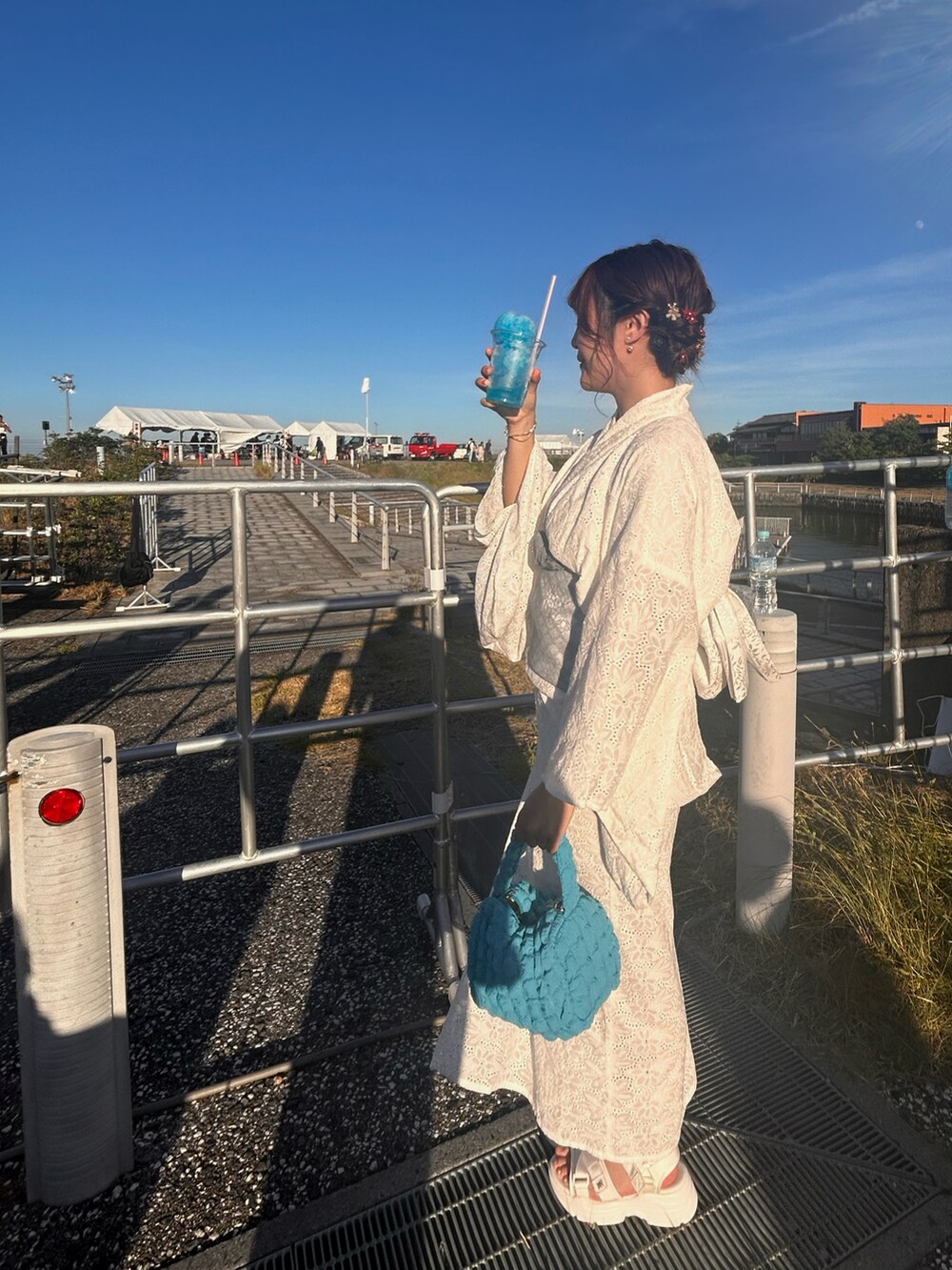 レッド系のヘアアクセサリーを着用したレディースの夏コーディネートの5枚目の写真