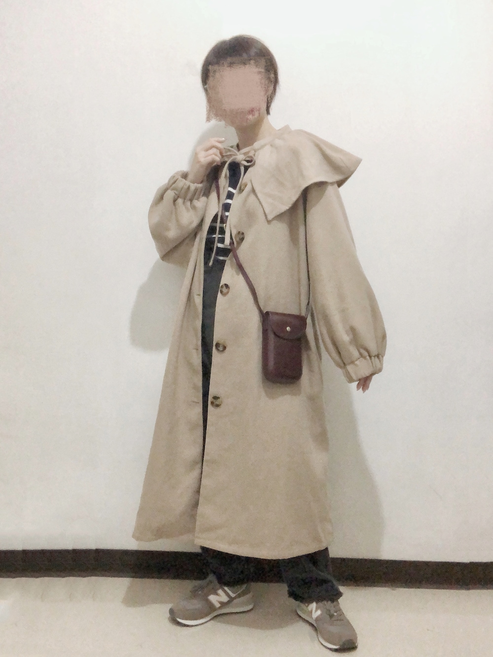 ブラック系のデニムパンツ、ベージュ系のその他アウター、ブラウン系のショルダーバッグを着用したレディースの冬コーディネートの2枚目の写真