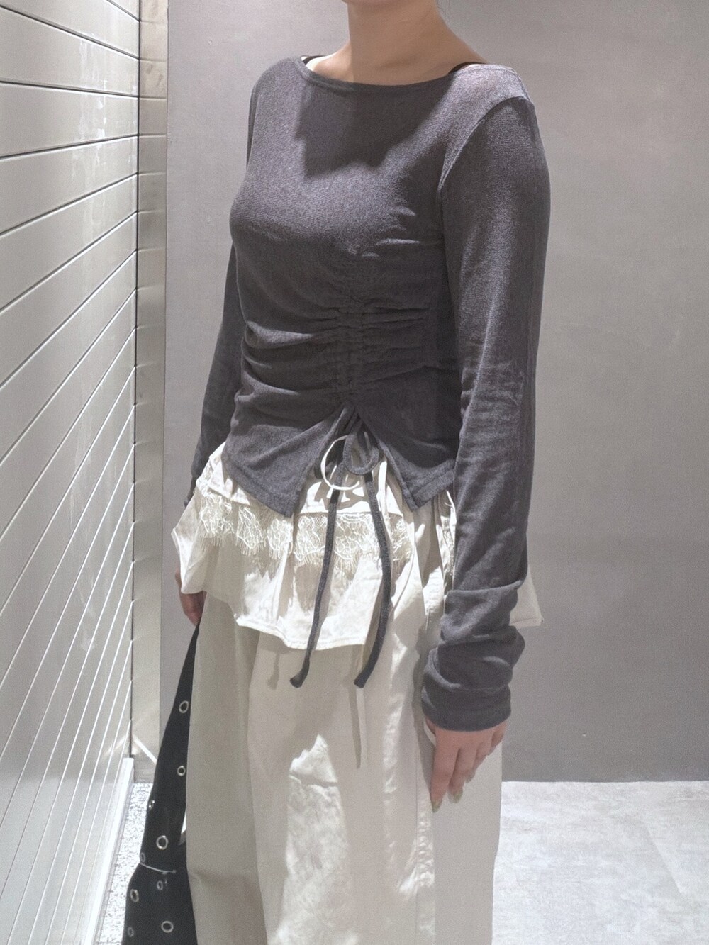 グレー系のTシャツ/カットソー、ホワイト系のその他パンツ、ブラック系のショルダーバッグを着用したレディースの秋コーディネートの5枚目の写真