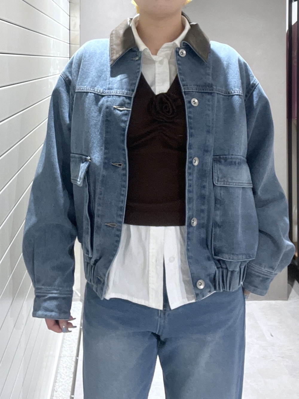 ブルー系のデニムジャケット、ホワイト系のシャツ/ブラウス、ブラウン系のニット/セーターを着用したレディースの冬コーディネートの6枚目の写真