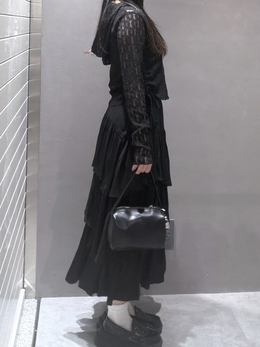 ブラック系のTシャツ/カットソー、ブラック系のスカート、ブラック系のハンドバッグを着用したレディースの春コーディネートの2枚目の写真