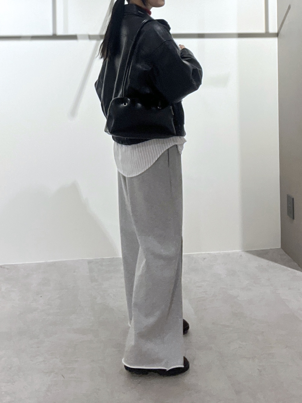 ホワイト系のシャツ/ブラウス、レッド系のニット/セーター、ブラック系のブルゾンを着用したレディースの冬コーディネートの2枚目の写真