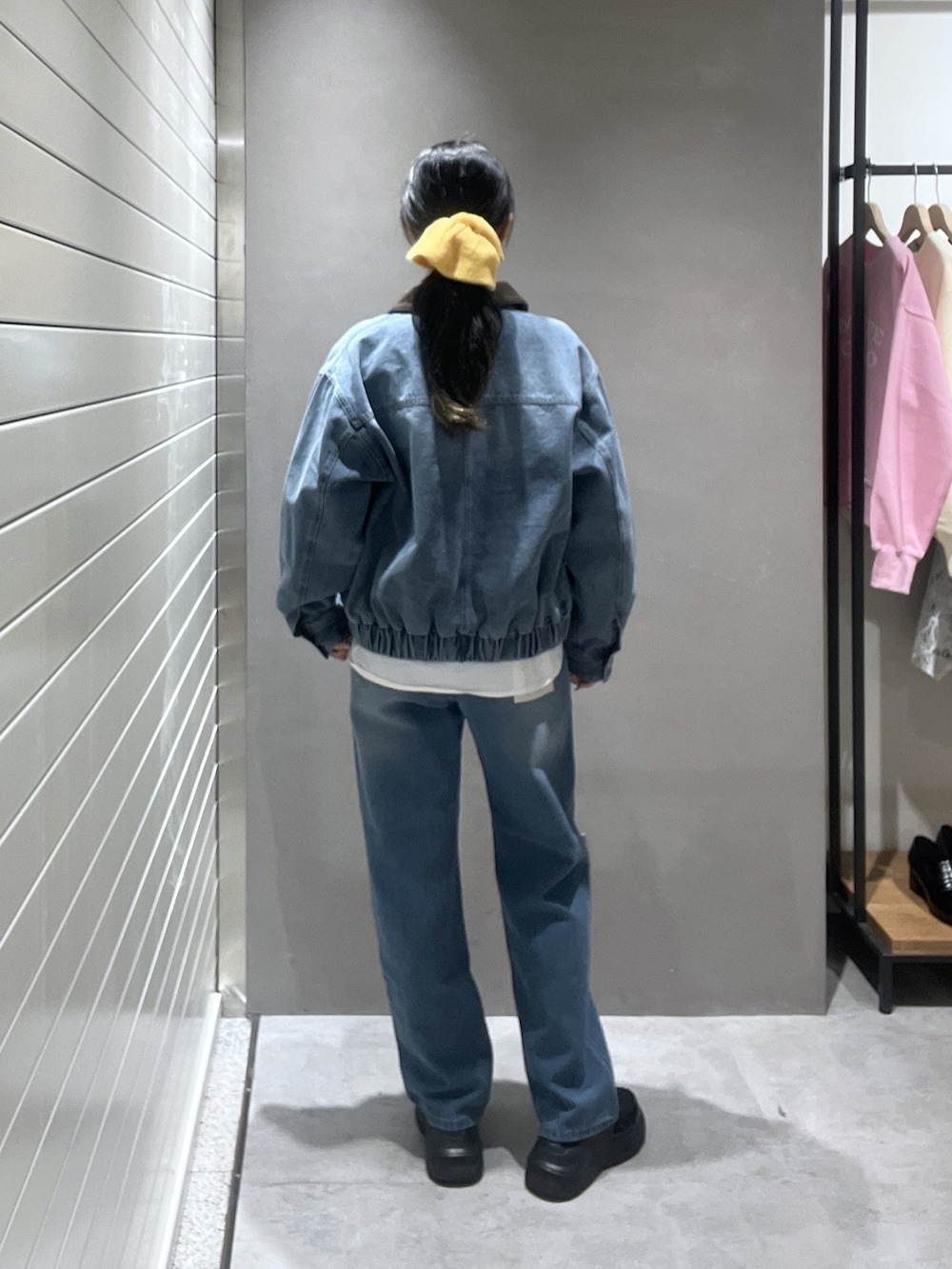 ブルー系のデニムジャケット、ホワイト系のシャツ/ブラウス、ブラウン系のニット/セーターを着用したレディースの冬コーディネートの2枚目の写真