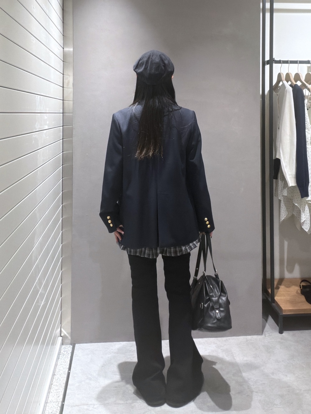 ブルー系のテーラードジャケット、レッド系のニット/セーター、ブラック系のスカートを着用したレディースの春コーディネートの3枚目の写真