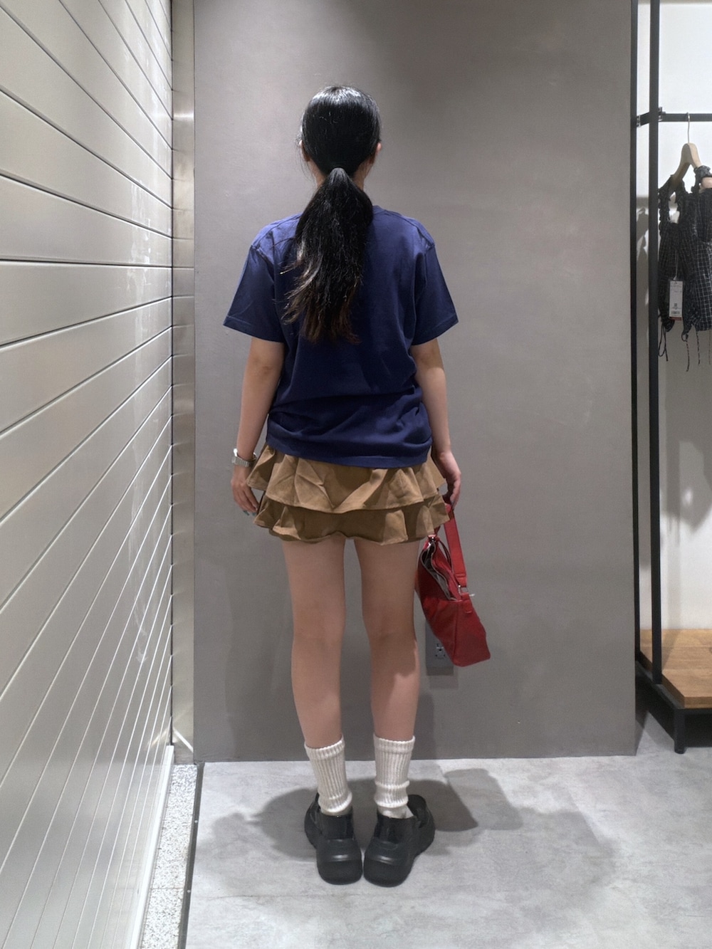 ブルー系のTシャツ/カットソー、ベージュ系のスカート、レッド系のショルダーバッグを着用したレディースの夏コーディネートの3枚目の写真