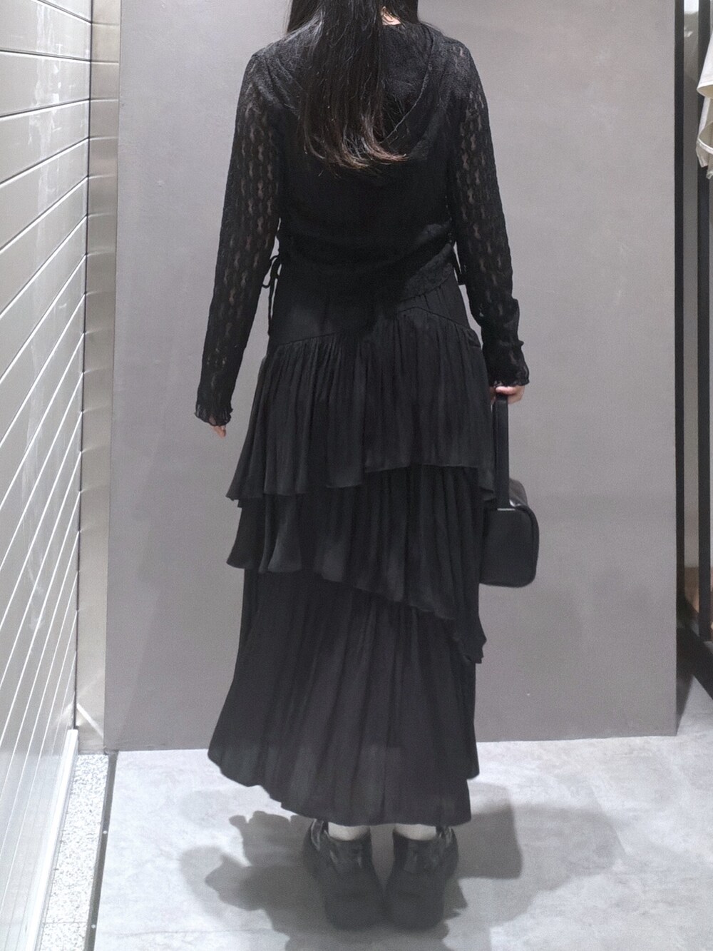 ブラック系のTシャツ/カットソー、ブラック系のスカート、ブラック系のハンドバッグを着用したレディースの春コーディネートの3枚目の写真