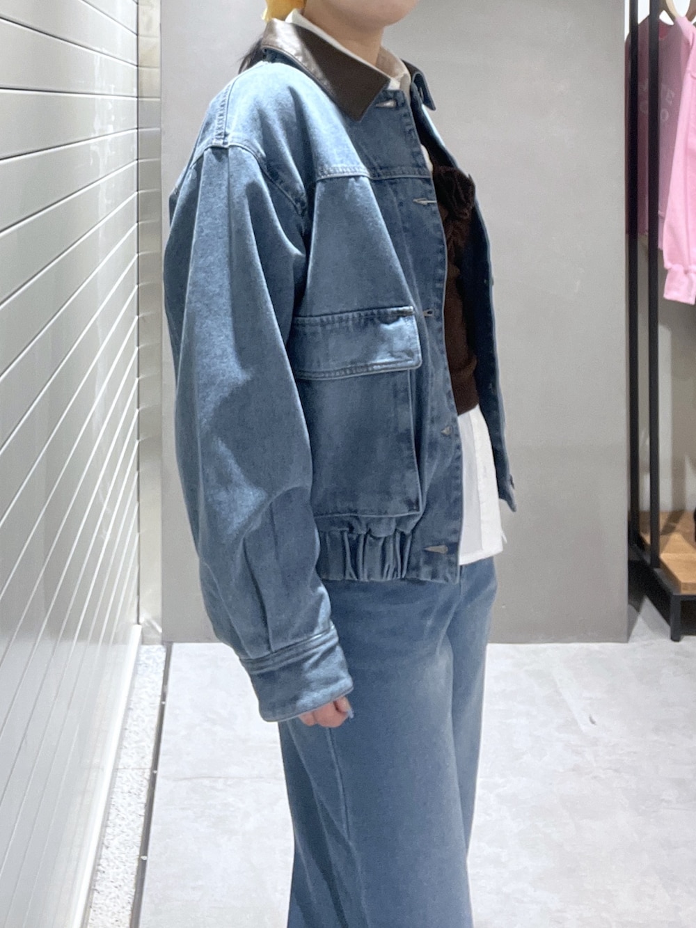 ブルー系のデニムジャケット、ホワイト系のシャツ/ブラウス、ブラウン系のニット/セーターを着用したレディースの冬コーディネートの4枚目の写真