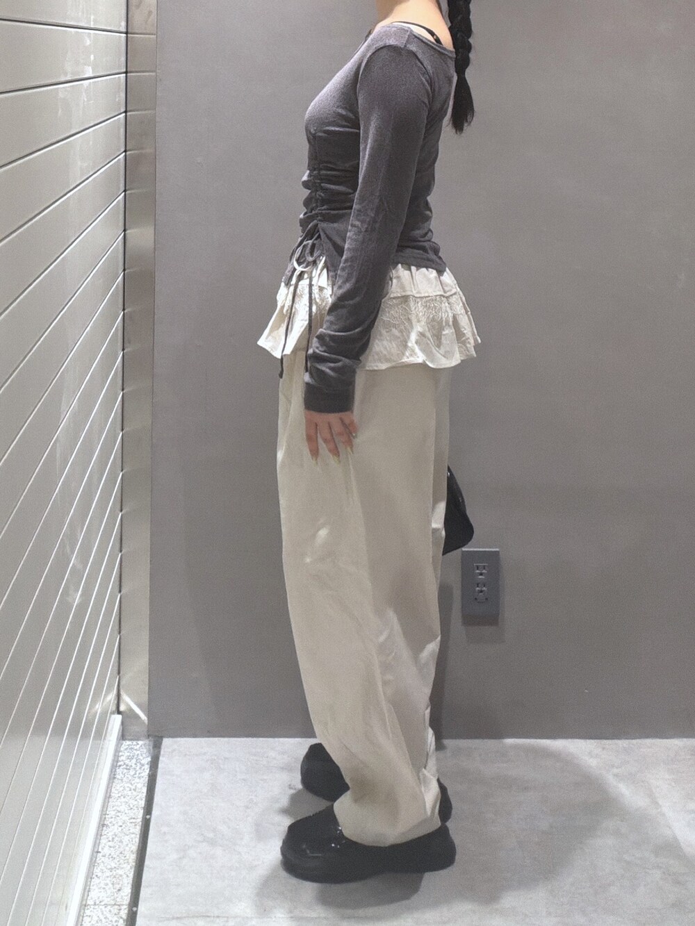 グレー系のTシャツ/カットソー、ホワイト系のその他パンツ、ブラック系のショルダーバッグを着用したレディースの秋コーディネートの2枚目の写真