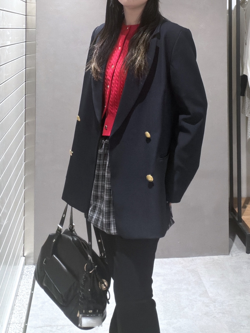 ブルー系のテーラードジャケット、レッド系のニット/セーター、ブラック系のスカートを着用したレディースの春コーディネートの5枚目の写真