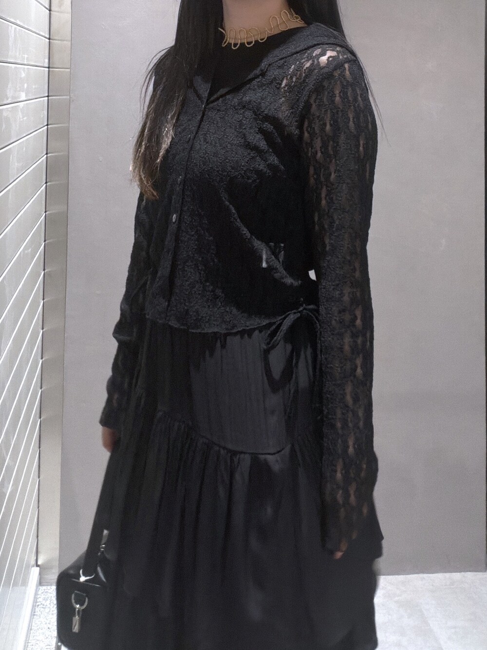 ブラック系のTシャツ/カットソー、ブラック系のスカート、ブラック系のハンドバッグを着用したレディースの春コーディネートの5枚目の写真