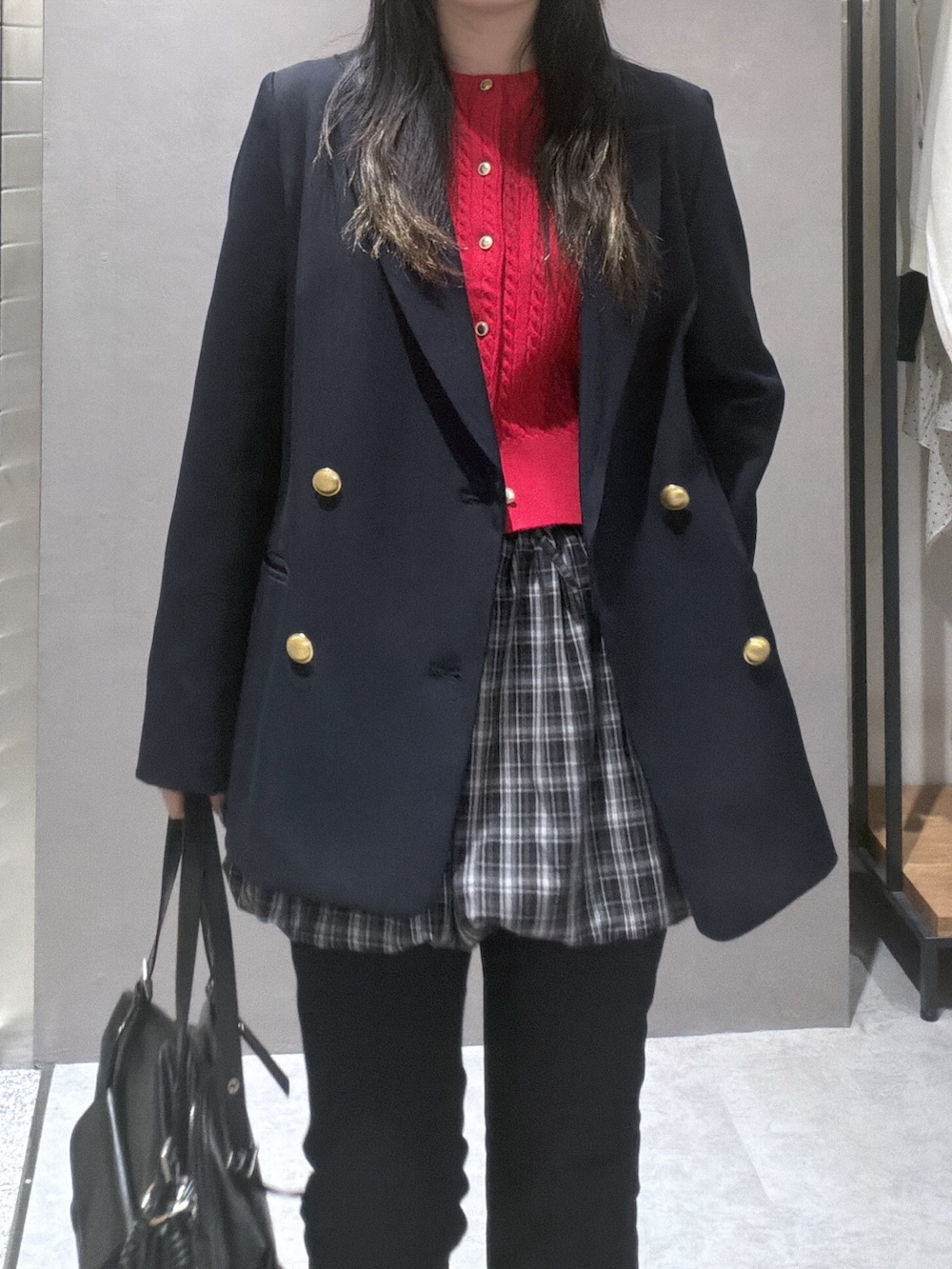 ブルー系のテーラードジャケット、レッド系のニット/セーター、ブラック系のスカートを着用したレディースの春コーディネートの4枚目の写真