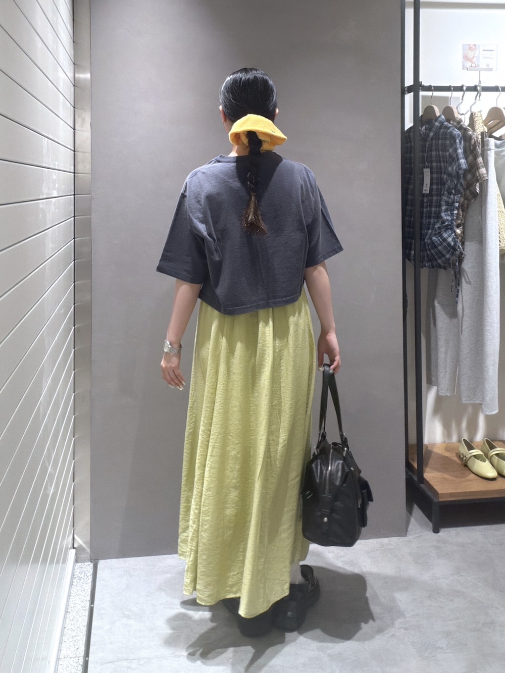 ブルー系のTシャツ/カットソー、イエロー系のワンピース、ブラック系のショルダーバッグを着用したレディースの夏コーディネートの3枚目の写真