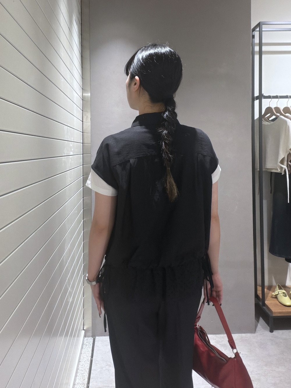 ブラック系のシャツ/ブラウス、ブラック系のTシャツ/カットソー、レッド系のショルダーバッグを着用したレディースの夏コーディネートの6枚目の写真