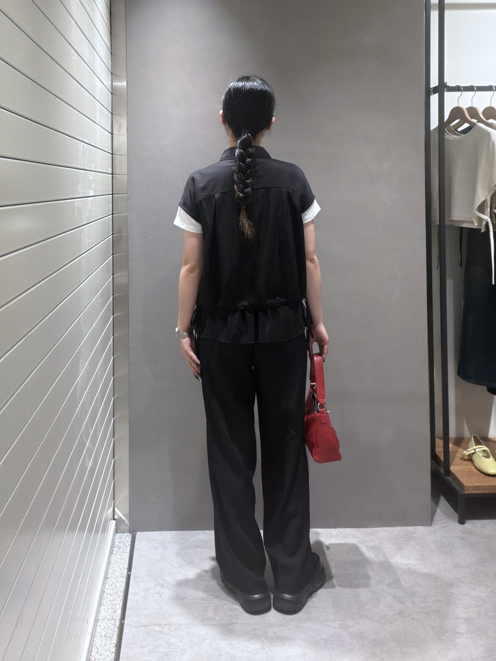 ブラック系のシャツ/ブラウス、ブラック系のTシャツ/カットソー、レッド系のショルダーバッグを着用したレディースの夏コーディネートの3枚目の写真