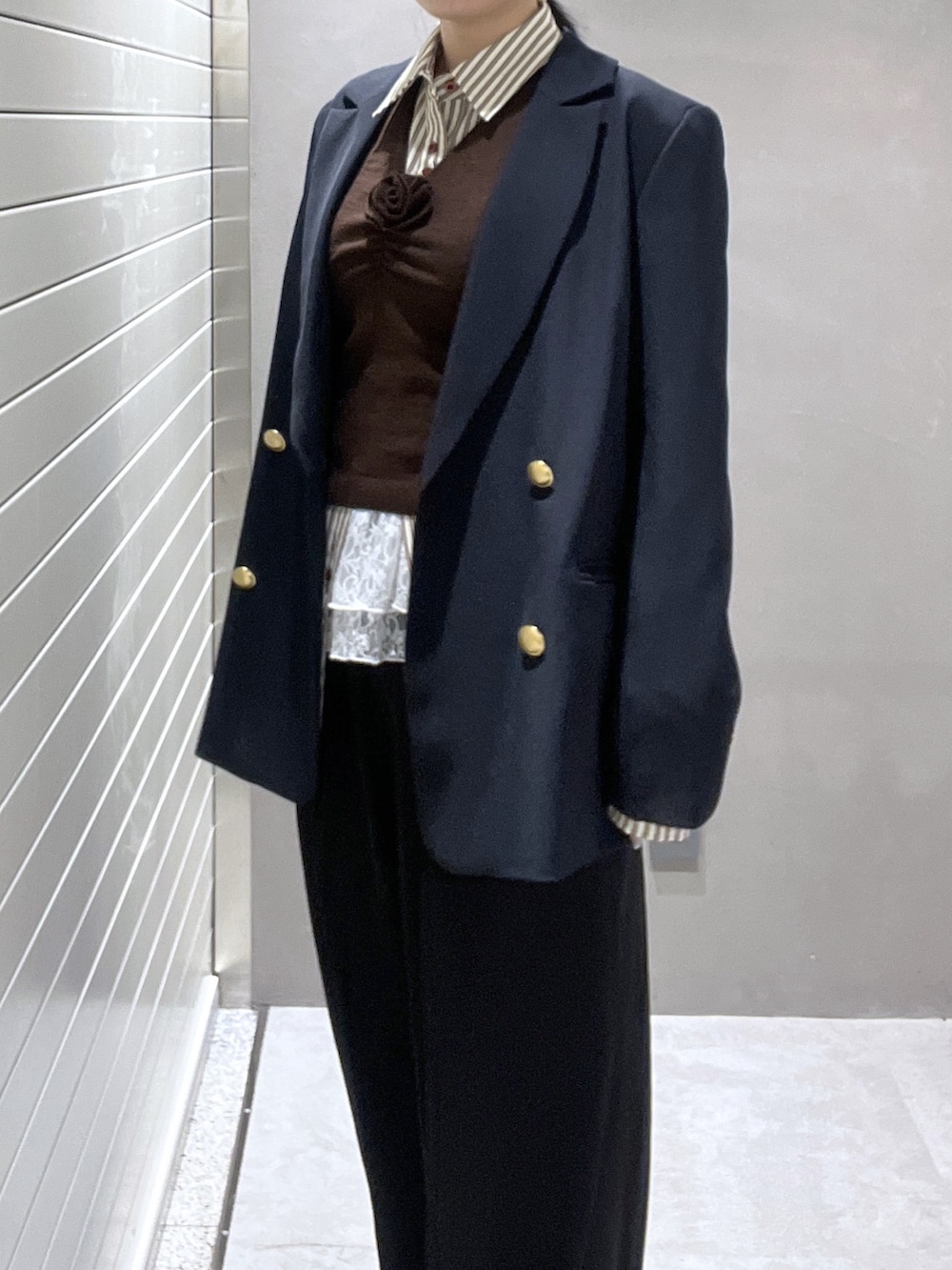 ブルー系のテーラードジャケット、ブラウン系のシャツ/ブラウス、ブラウン系のニット/セーターを着用したレディースの冬コーディネートの4枚目の写真